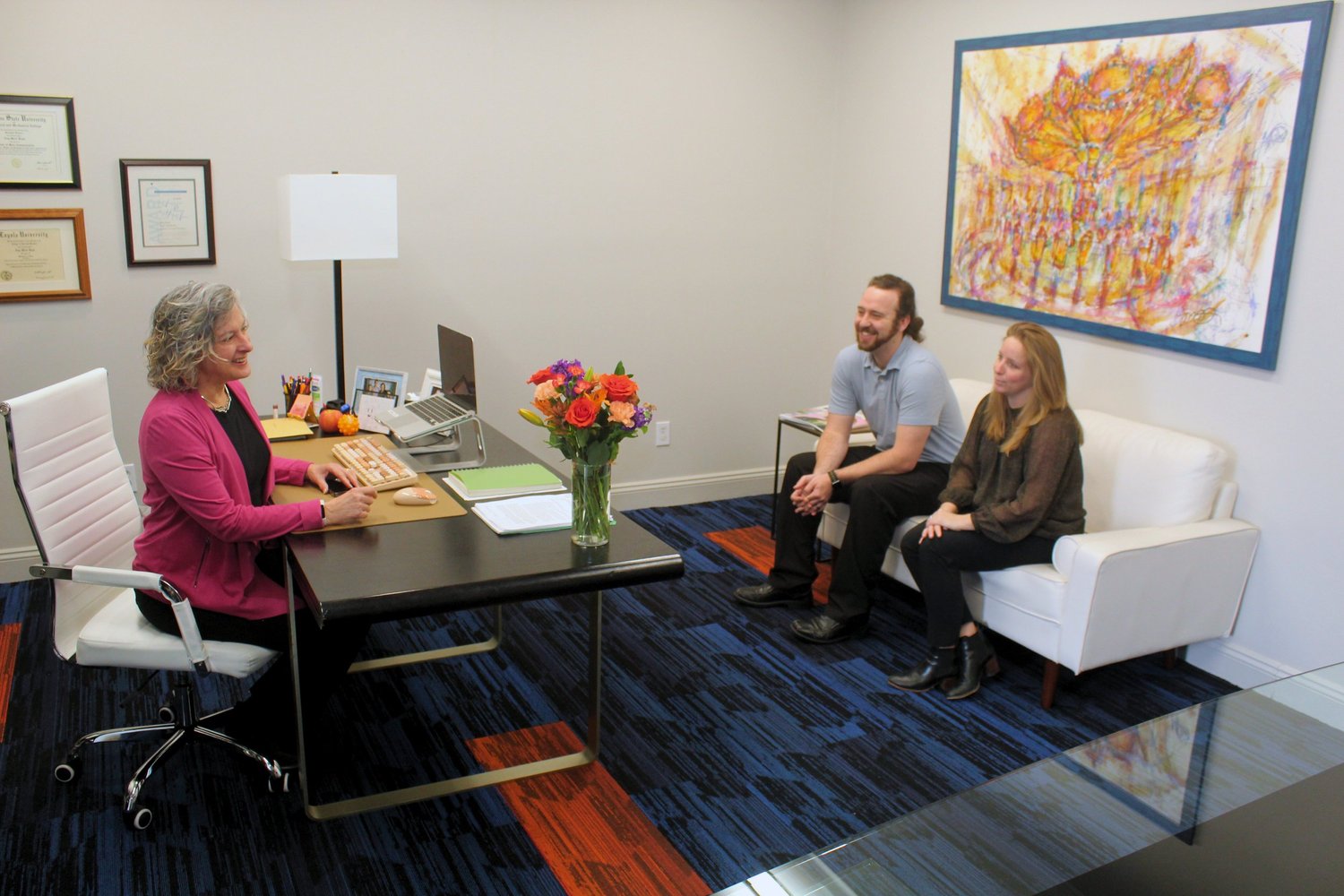 Three people in conversation inside Gambel Communications' Metairie office