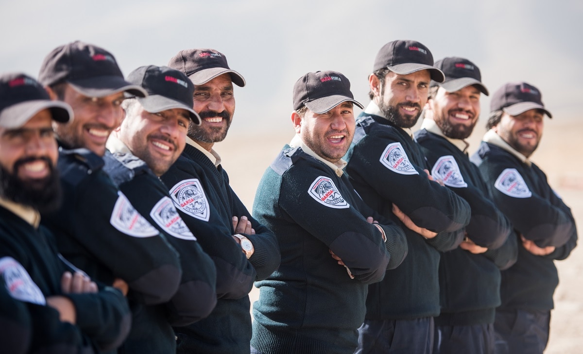 A line of GardaWorld security professionals standing outdoors