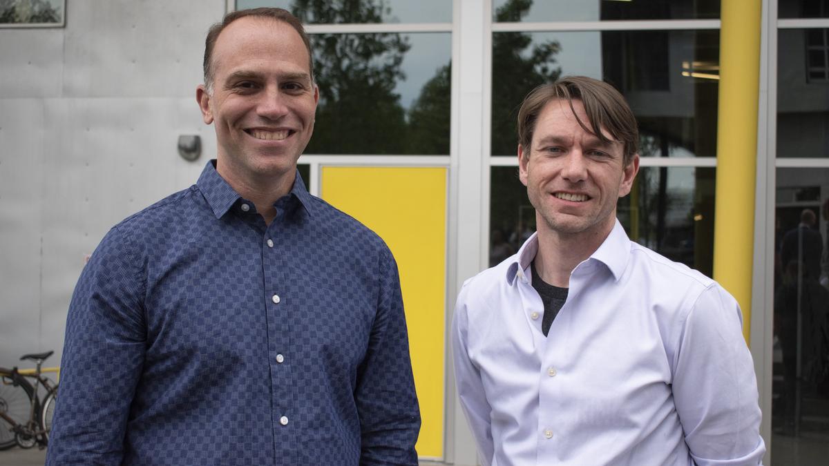 Peter Messana on the left and Gareth Dismore on the right, standing outside a building