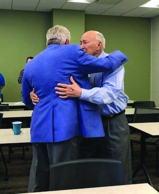 Ballard Cassady, left, embraces Garland Certain at a Kentucky Bankers Association group meeting.