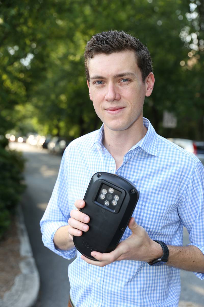 Garrett Langley outdoors holding an early Flock Safety camera