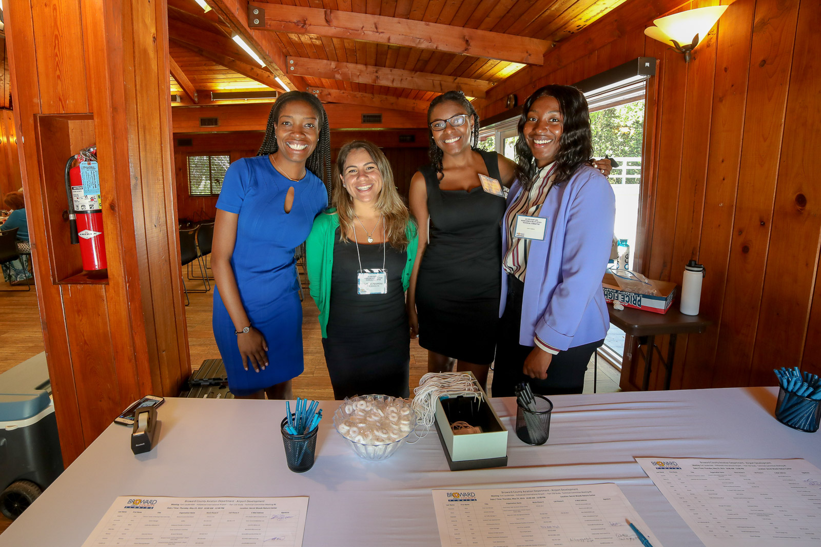 Four members of a public meeting team smiling behind a registration table at a Broward aviation event
