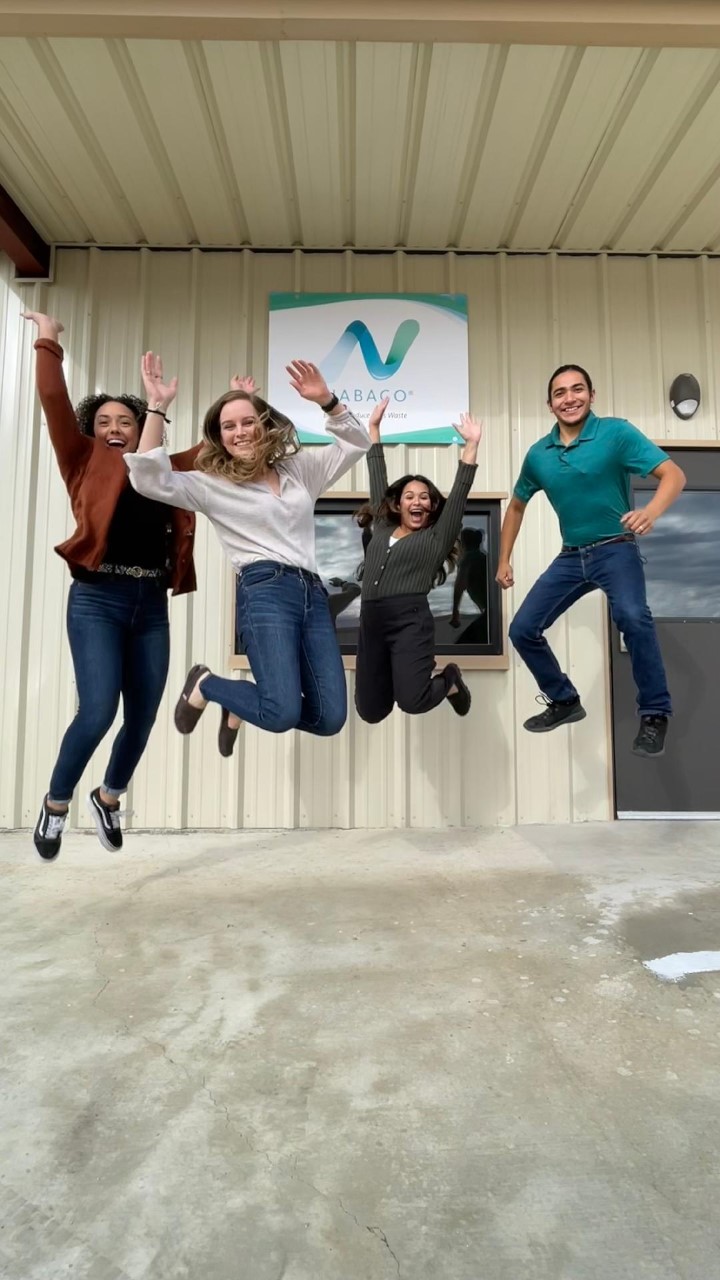 Four members of Nabaco’s research and development team jumping outside a Nabaco building