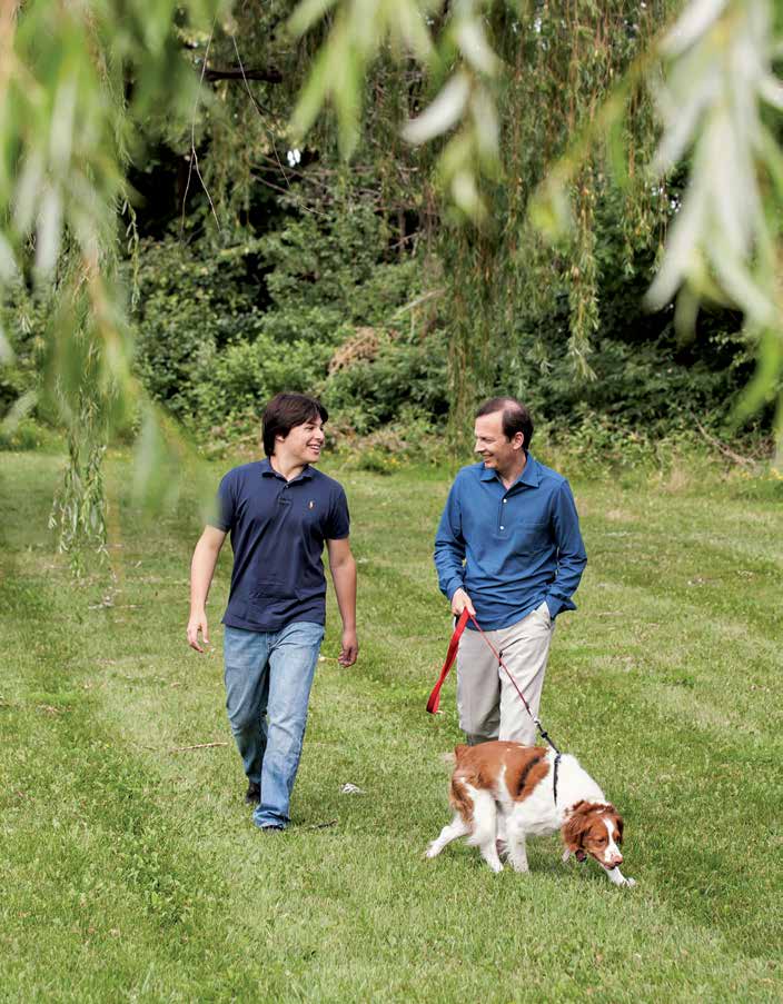 Gary Glick, on the right, walks outdoors with his son Jeremy and their dog Cooper in Ann Arbor