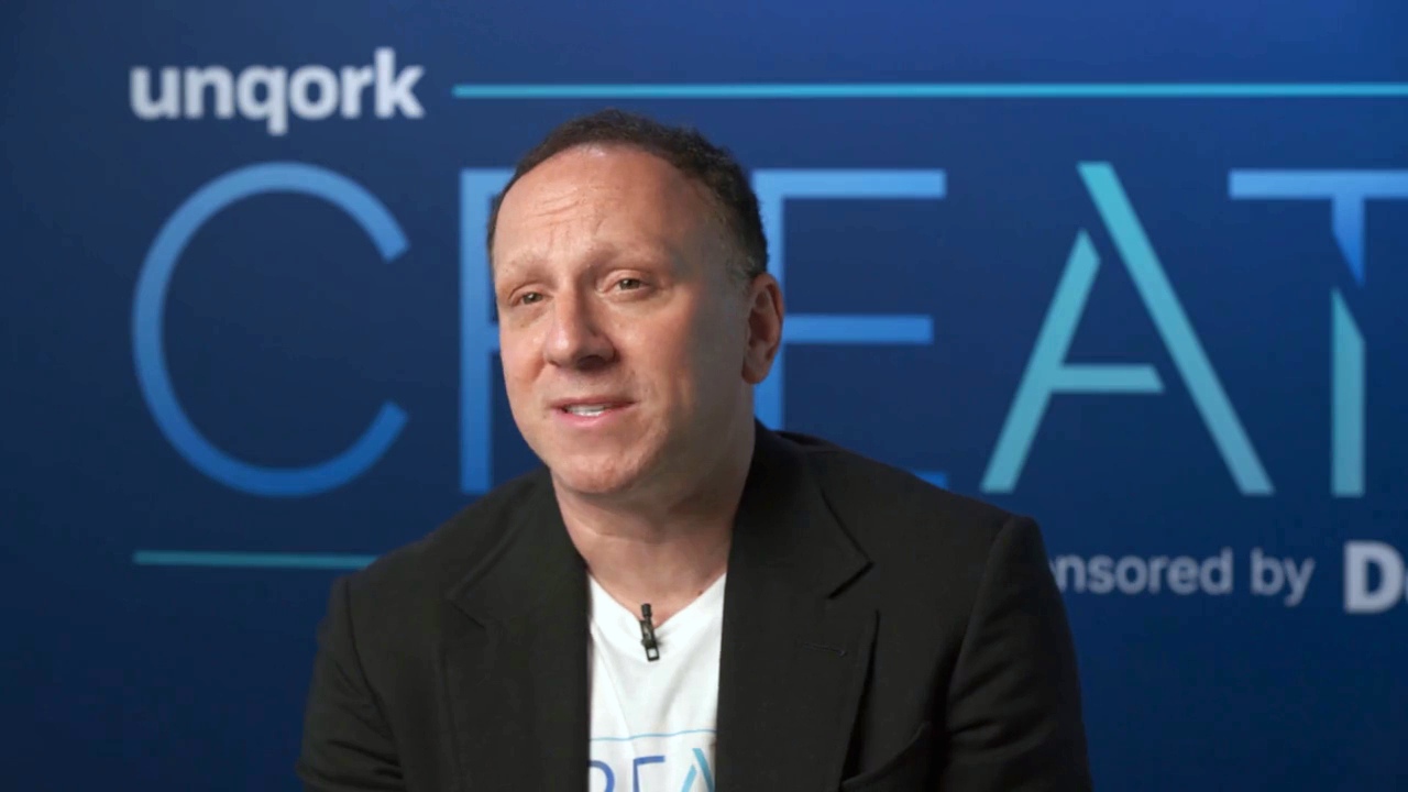 Gary Hoberman speaking in front of an Unqork CREATE backdrop