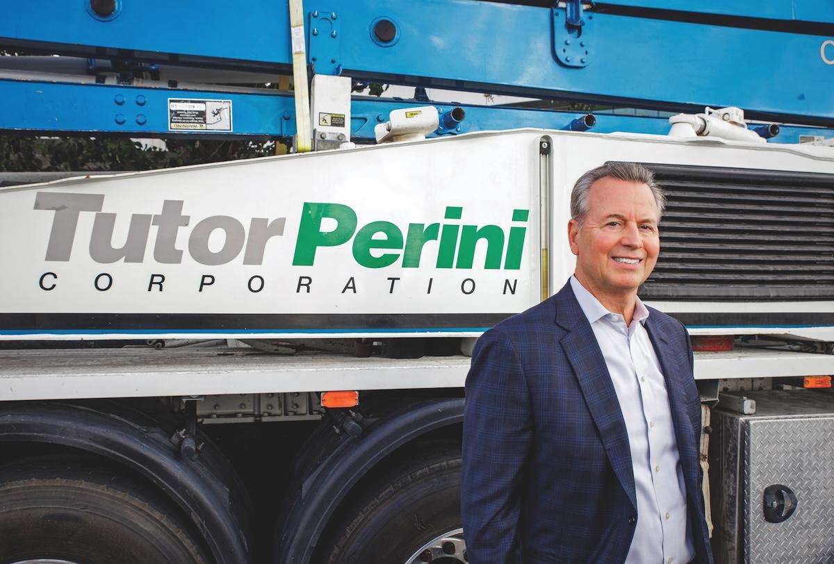 Gary Smalley standing beside Tutor Perini equipment at the company’s Sylmar headquarters