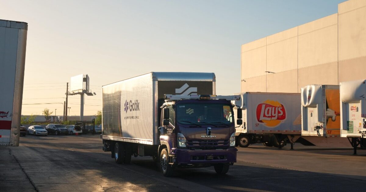 Purple Gatik autonomous freight truck at a logistics facility