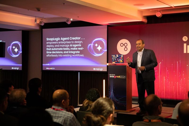 Gaurav Dhillon speaking beside an Agent Creator presentation at SnapLogic Integreat 2024