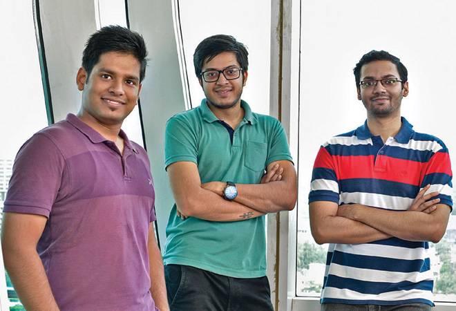 Three GoComet co-founders standing together in an office in a 2018 press photograph