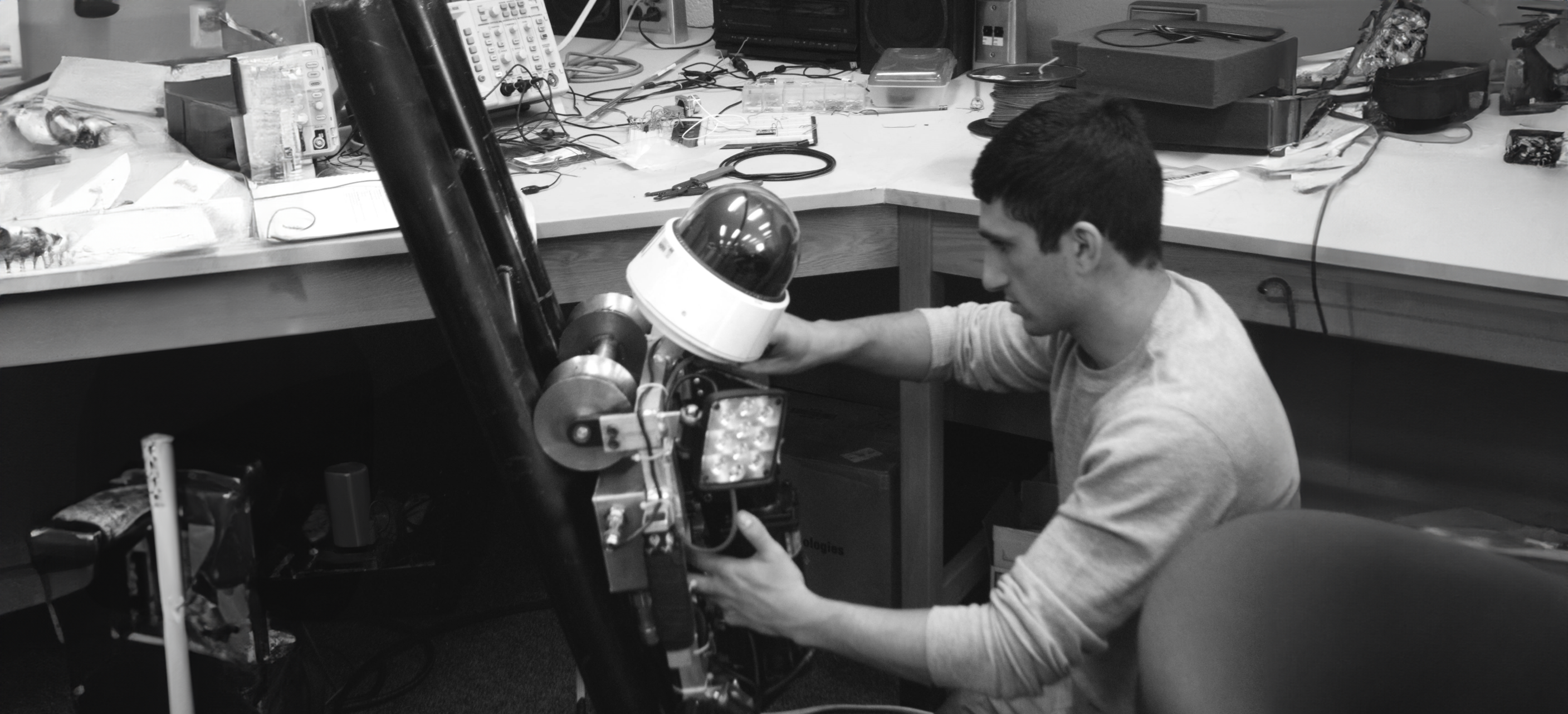 Jake Loosararian works on an early Gecko robot at a lab bench