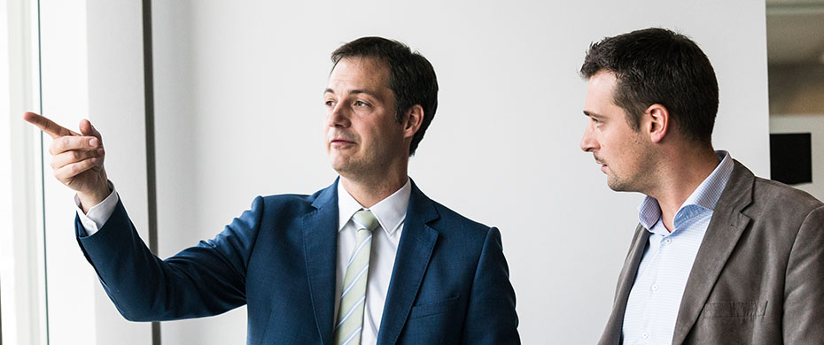 Alexander De Croo, left, gestures while Geert Houben listens beside him