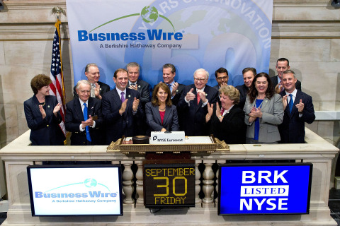 Business Wire executives, including CFO Geff Scott, celebrate the company’s 50th birthday on the NYSE opening-bell podium with Warren Buffett.