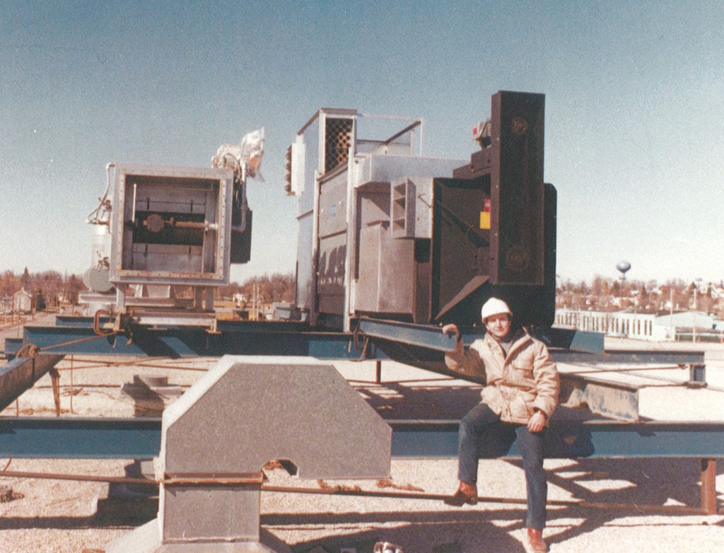 Gene Anguil standing beside an early environmental systems installation in 1978