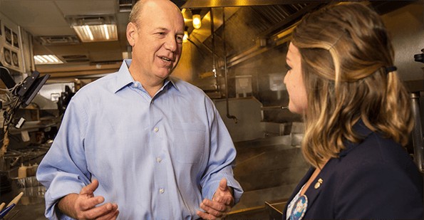 Gene Lee speaks with an Olive Garden employee in a restaurant kitchen