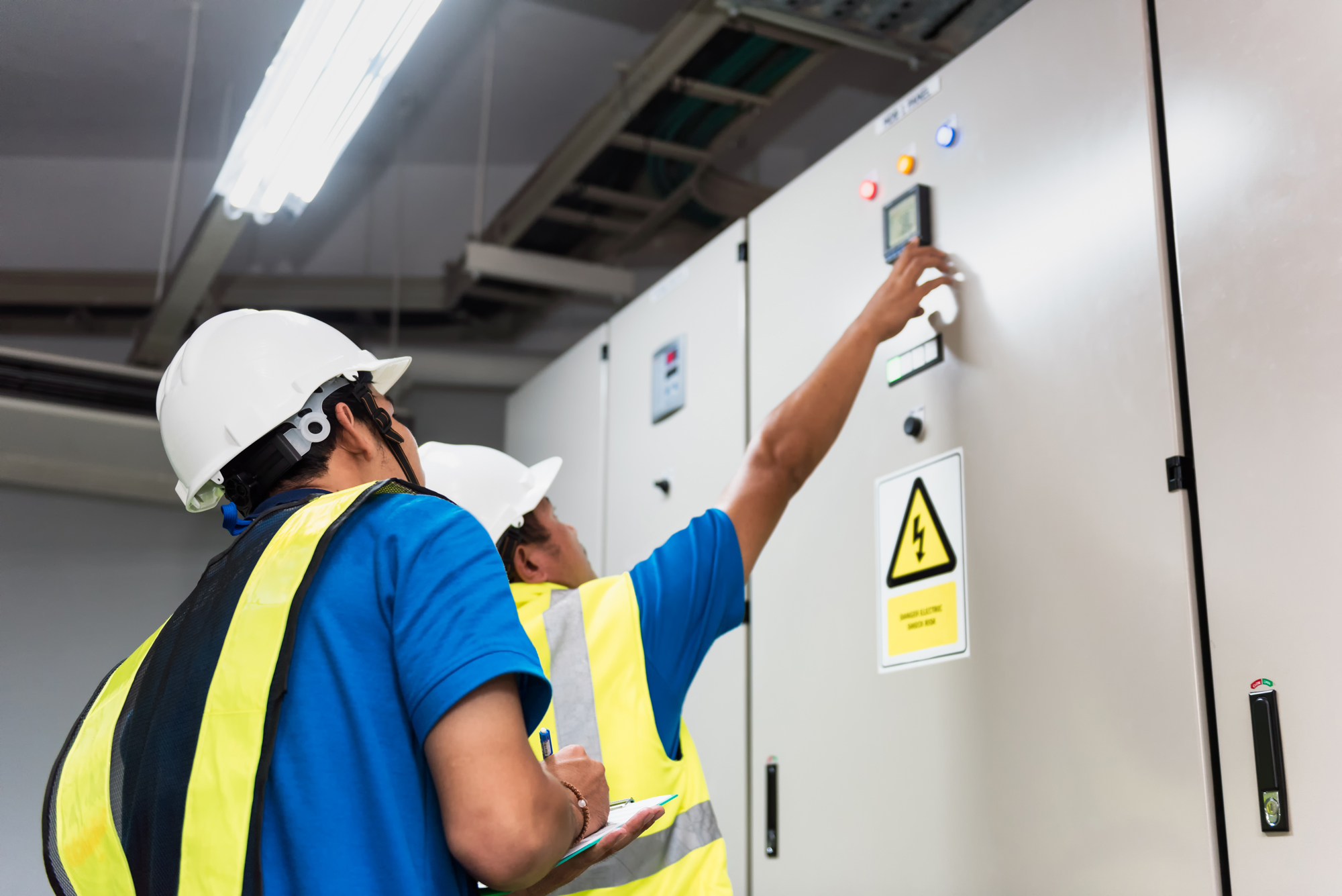 Engineers in hard hats examining HVAC equipment