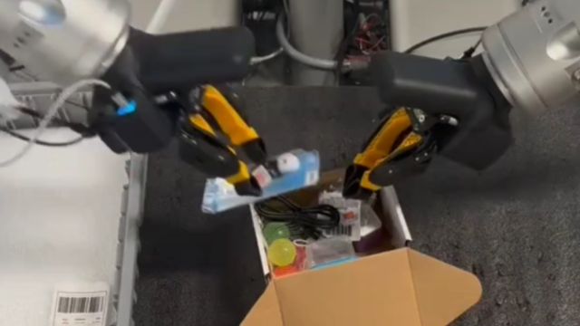 Two robotic arms placing objects into a box