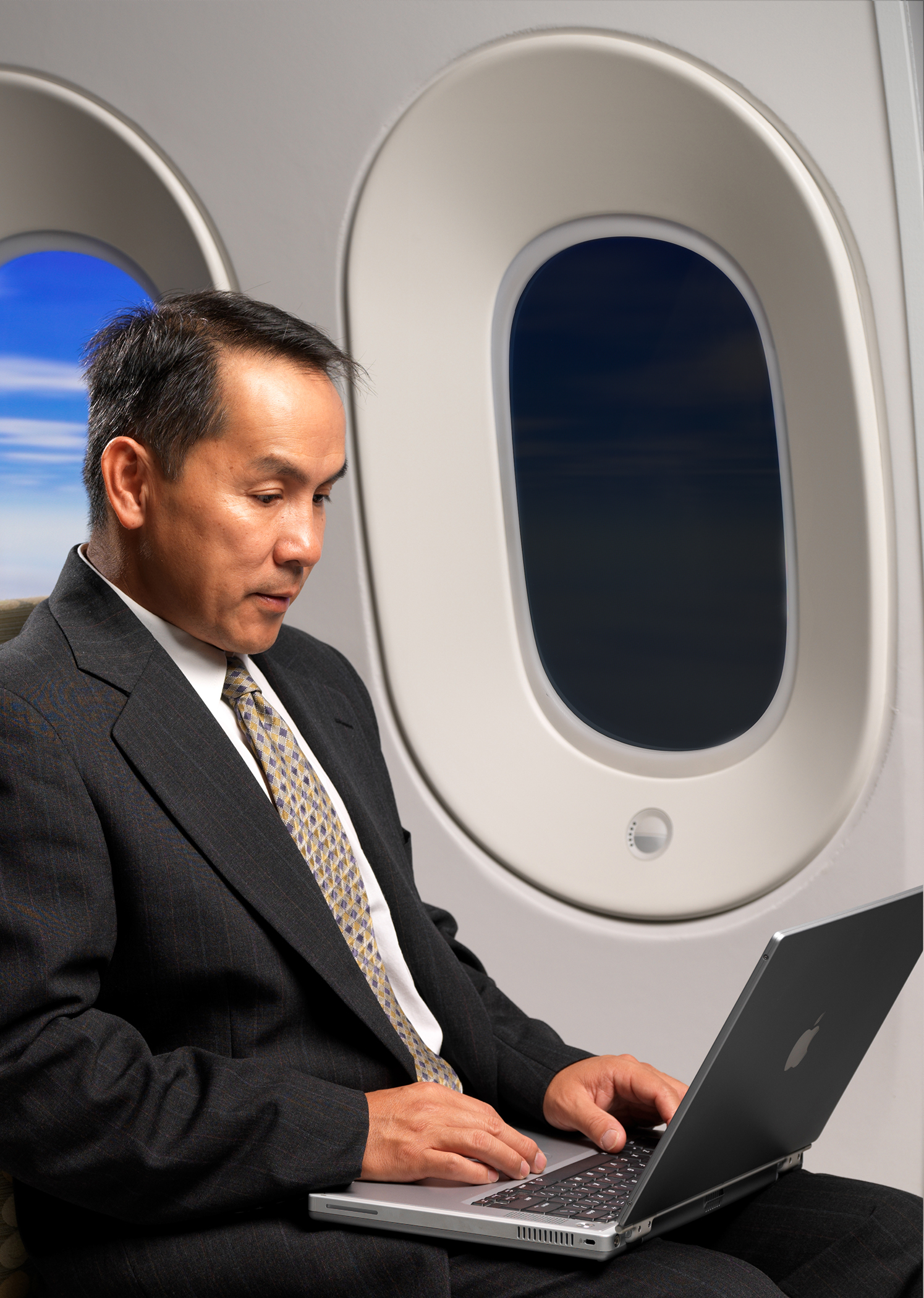 Passenger sitting beside an electronically dimmable aircraft window