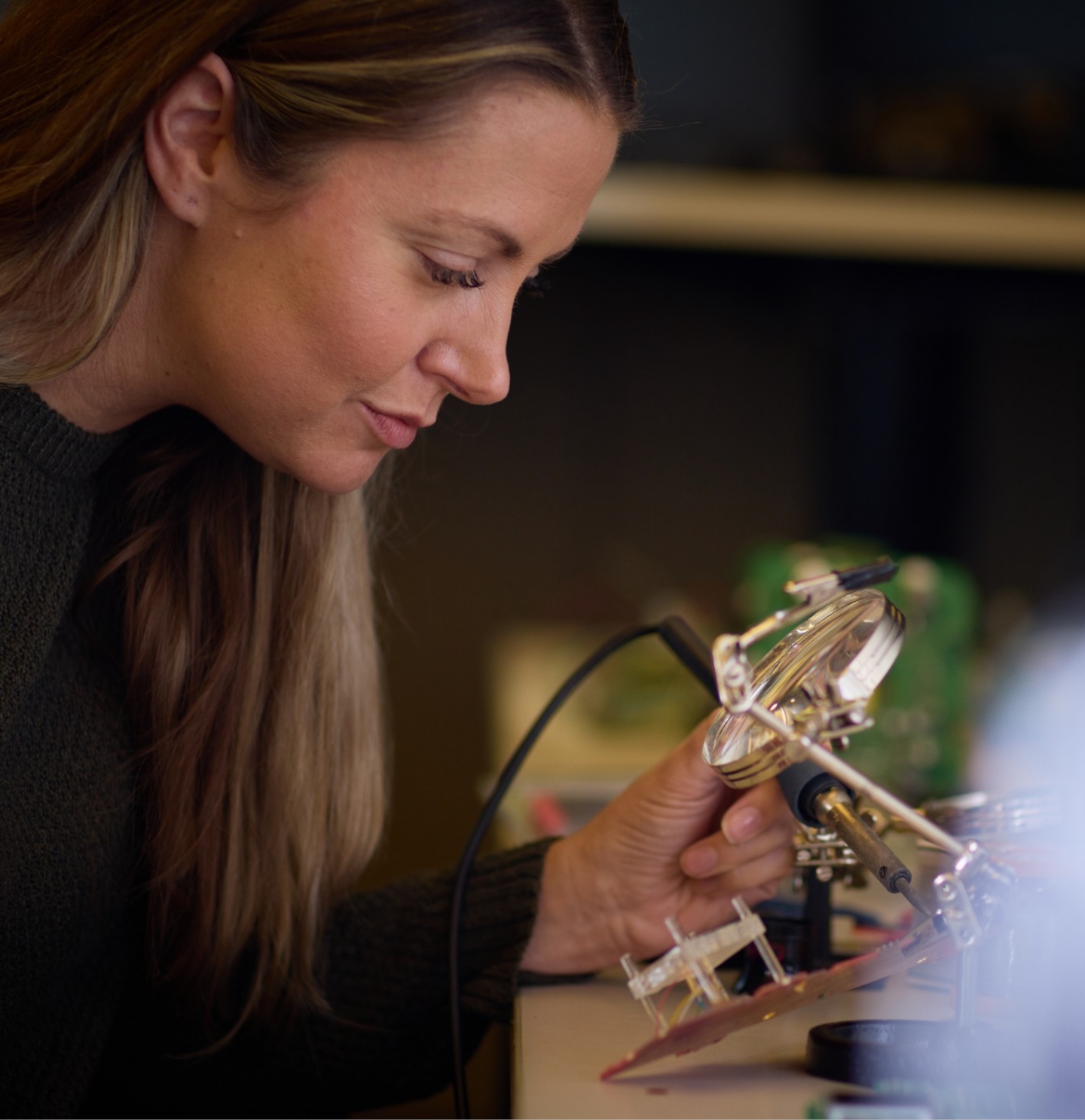 A person working on electronic components in a Gentex company photograph