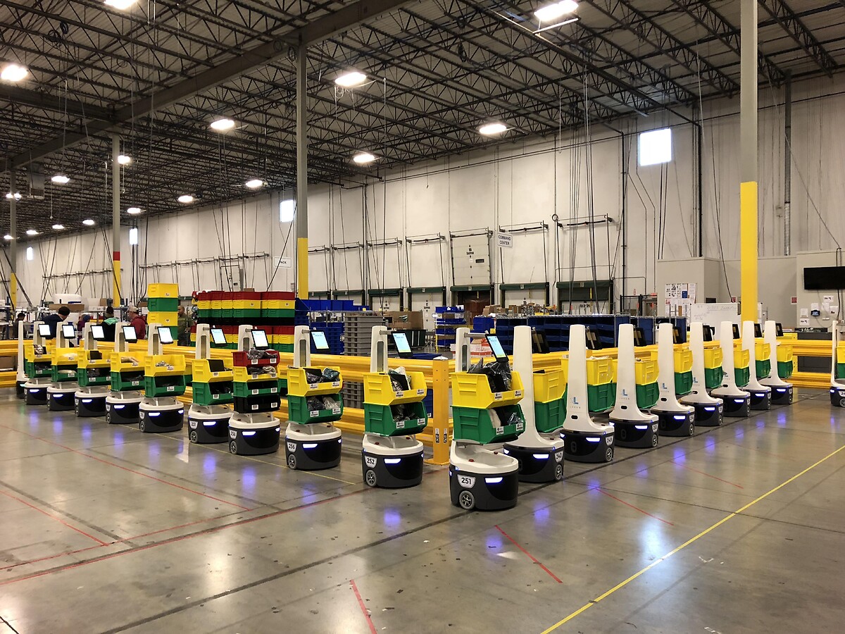 A fleet of Locus mobile robots with bins in a GEODIS warehouse