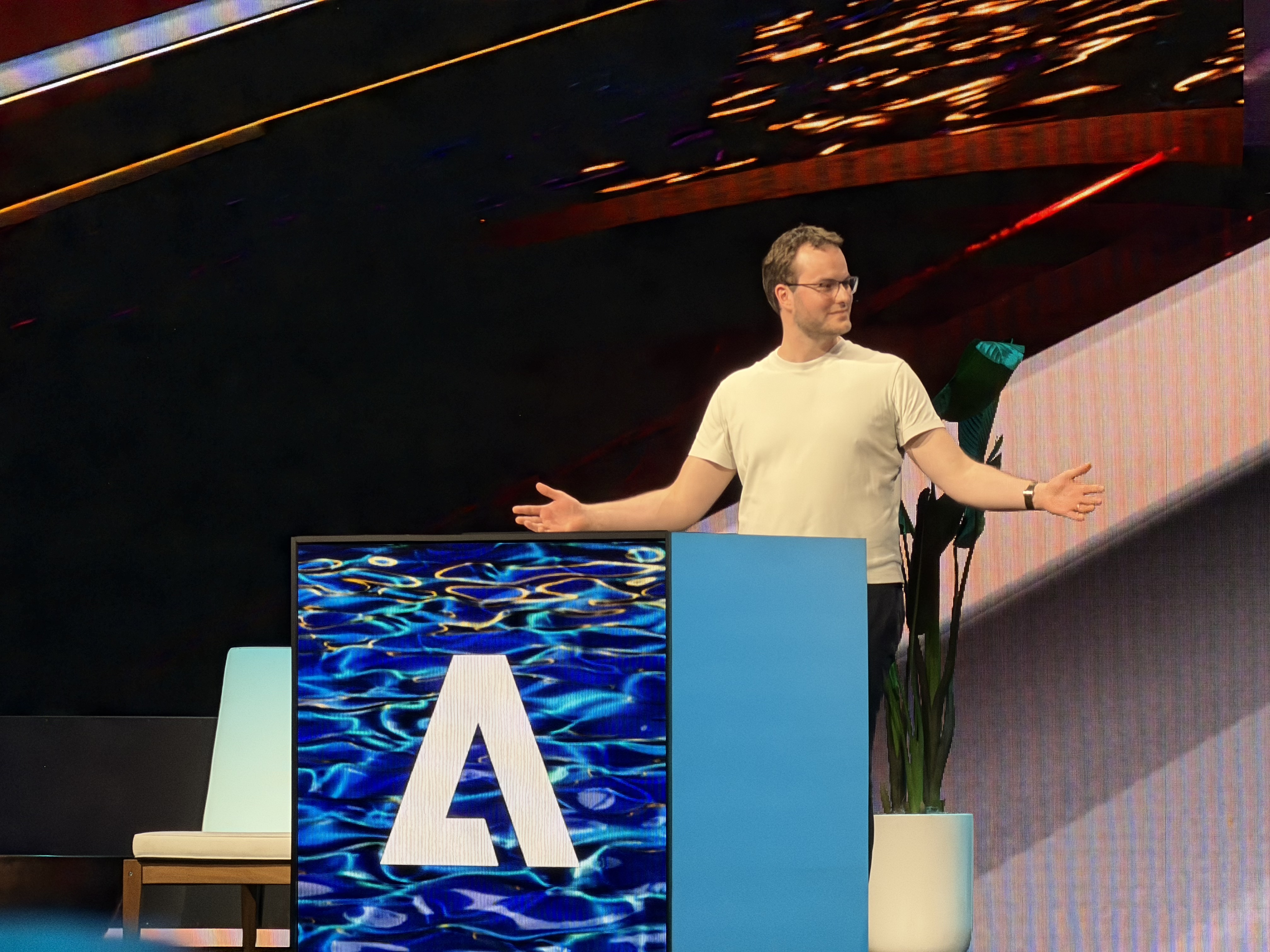 A presenter addresses the audience from the stage at Adobe MAX 2025