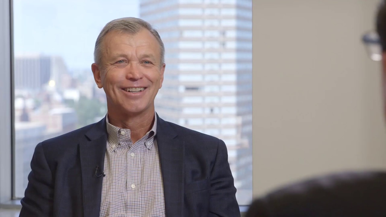 Geoff Rehnert smiling during his Privcap interview, seated across from an interviewer