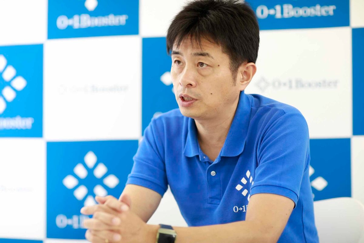 George Goda speaking in a blue 01Booster polo during an interview
