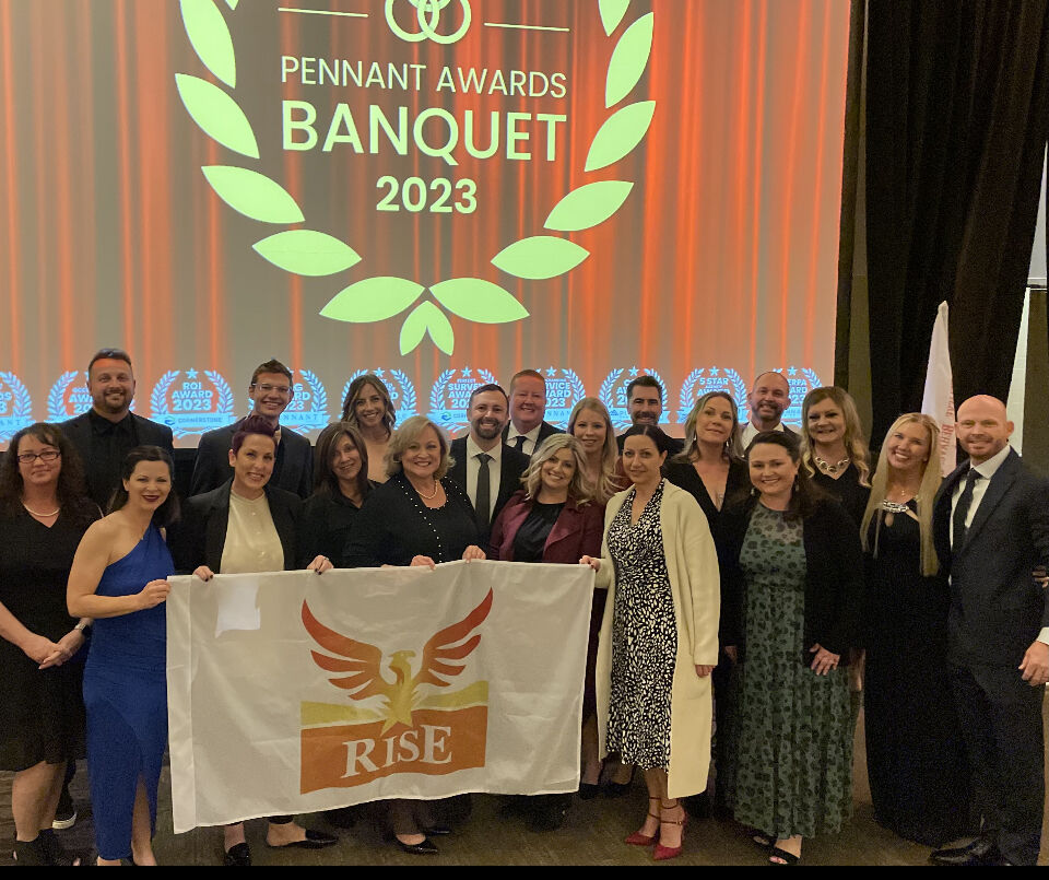 Group at the Pennant Awards Banquet 2023 gathered behind a RISE banner