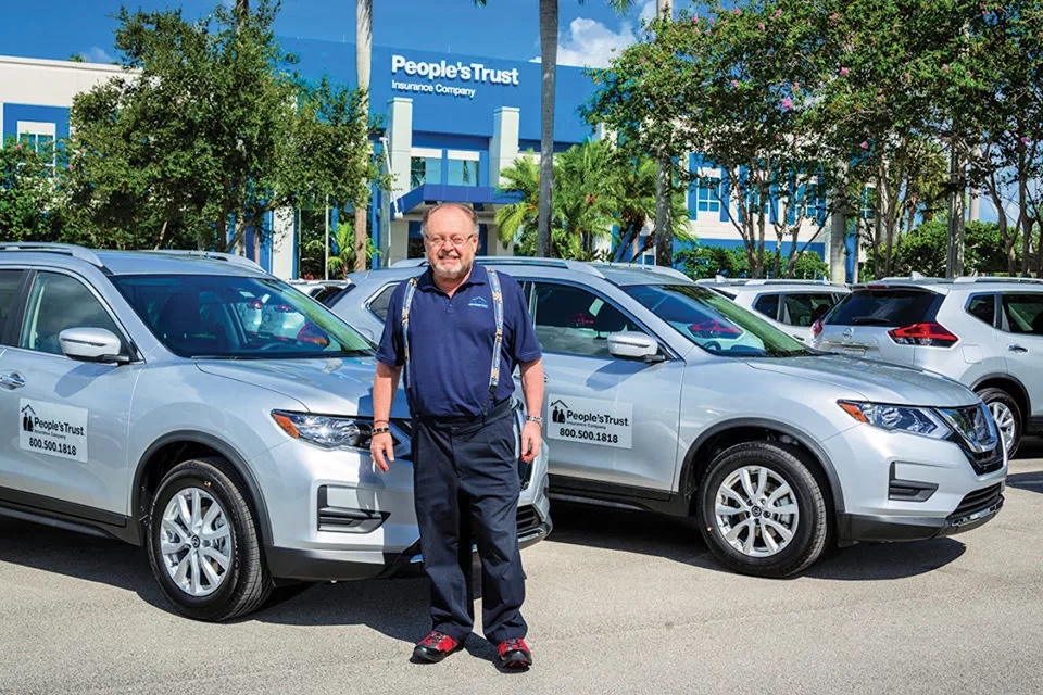 George Schaeffer standing beside People’s Trust vehicles outside the company’s offices