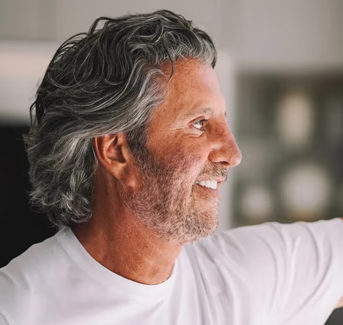 Gerry Powell smiling in a white shirt, photographed in profile