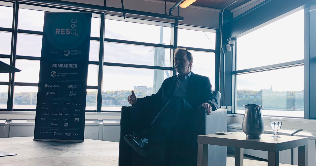 Germain Lamonde seated in conversation at a Quebec City business event