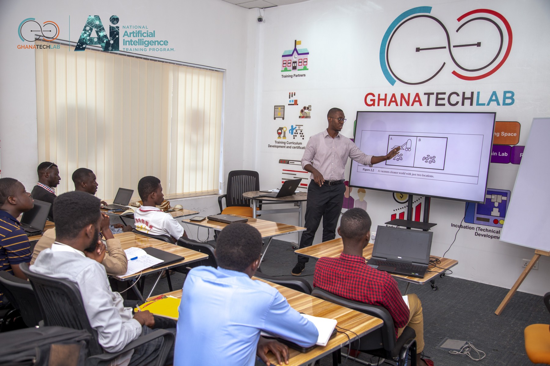 An instructor presenting to participants with laptops in a Ghana Tech Lab training room