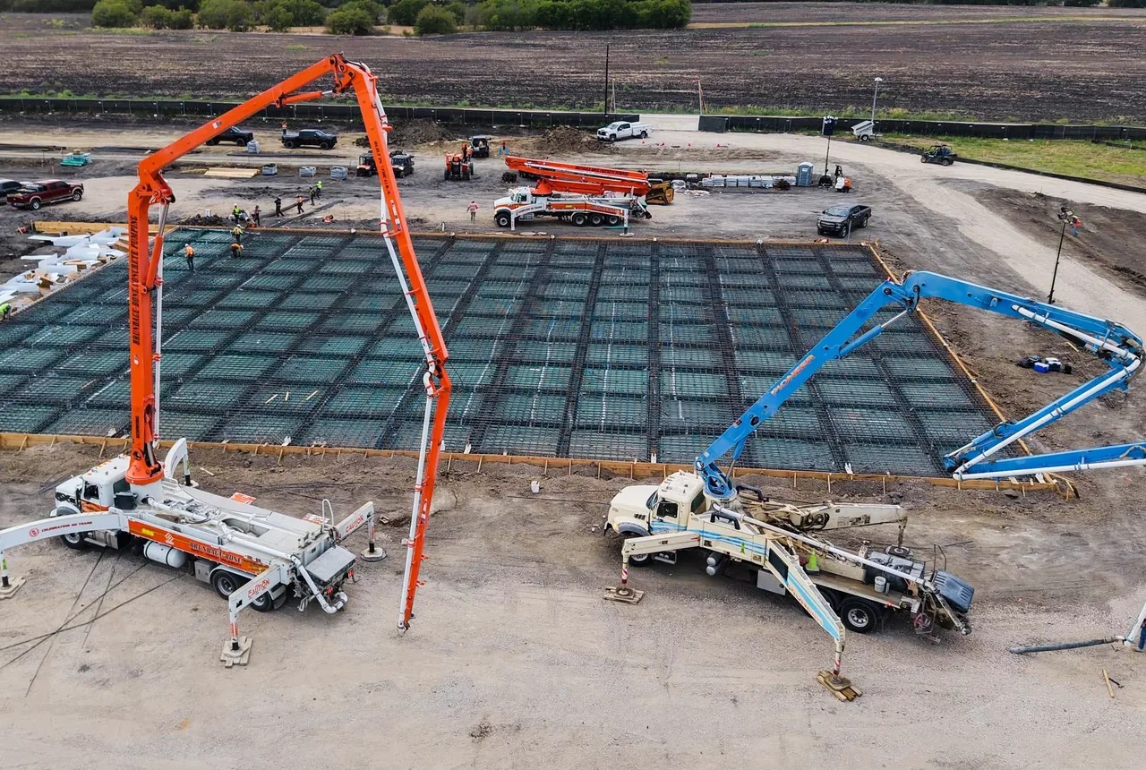 Two cranes placing infrastructure at a Giga data center construction site