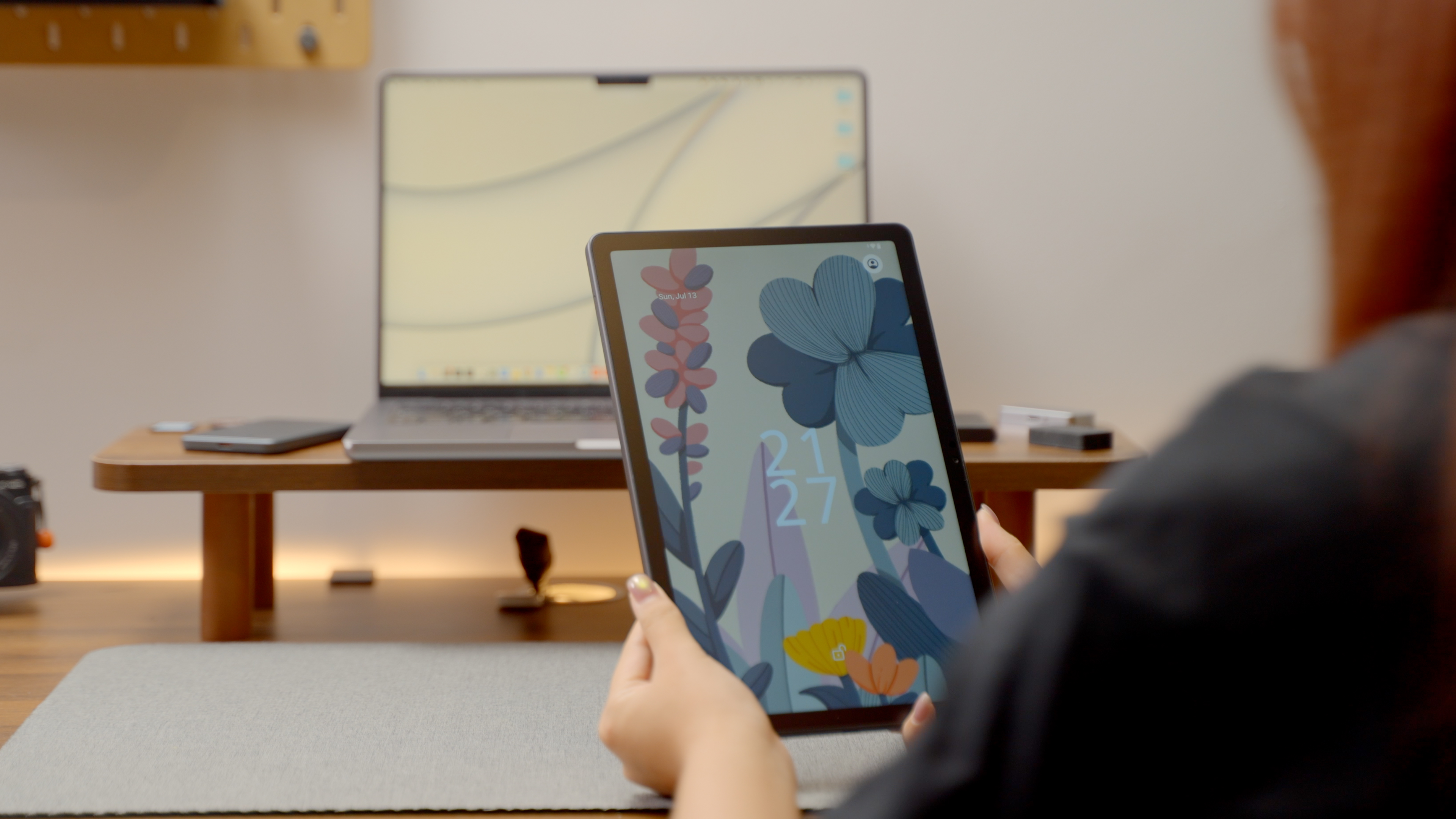 A person holds the Huion drawing tablet in front of a laptop