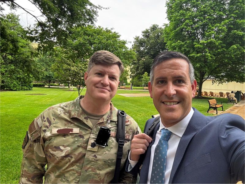 Giles Whiting standing outdoors beside a United States Air Force officer
