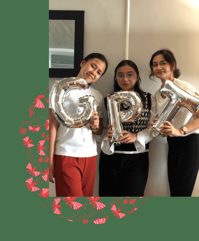 Three members of the Girl Power Talk team holding silver letter balloons