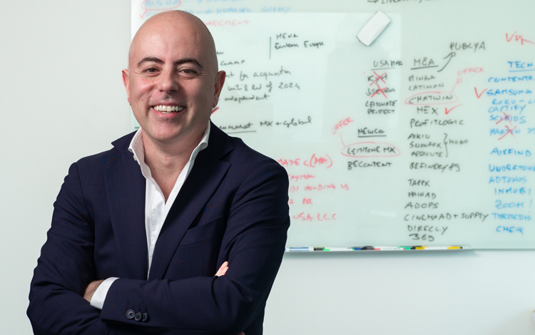 Giuliano Stiglitz standing in front of a whiteboard covered with business notes