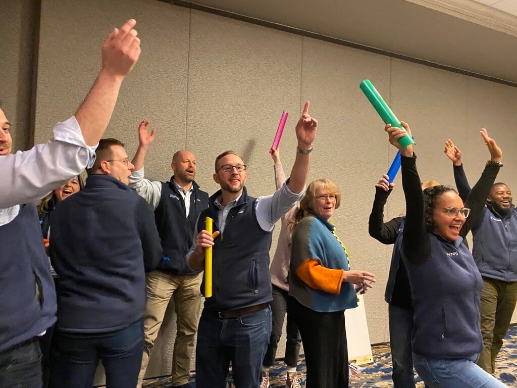 Members of the Givzey team celebrating together with colorful noisemakers