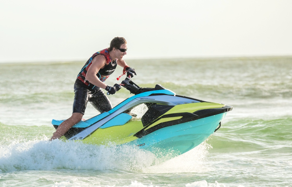 Rider on a turquoise and lime Yamaha JetBlaster cutting through the water