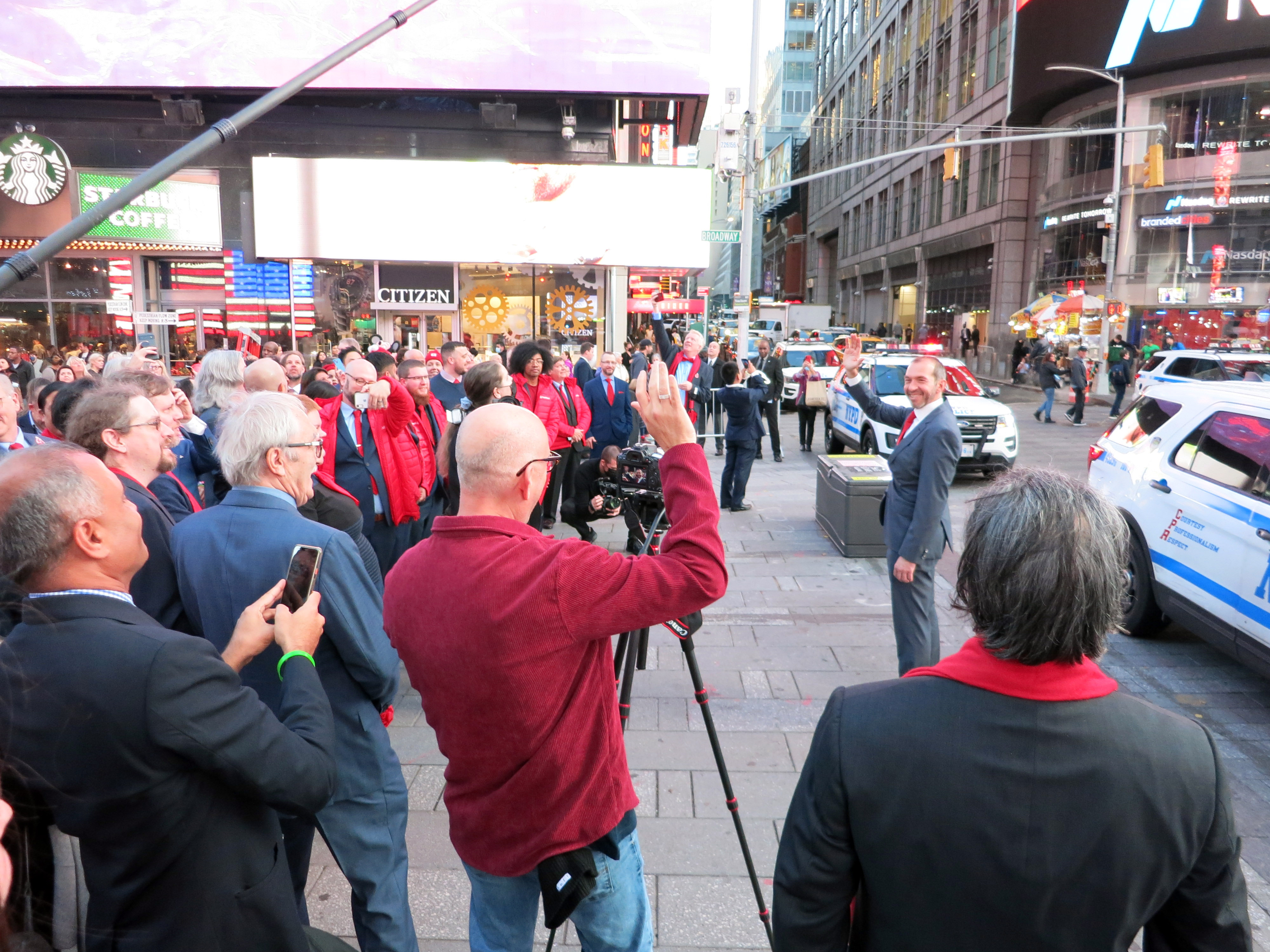 Gleb Budman waves to a camera while Backblaze colleagues gather in Times Square