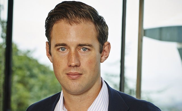 Glen Calvert during his Affectv years, in a suit beside office windows
