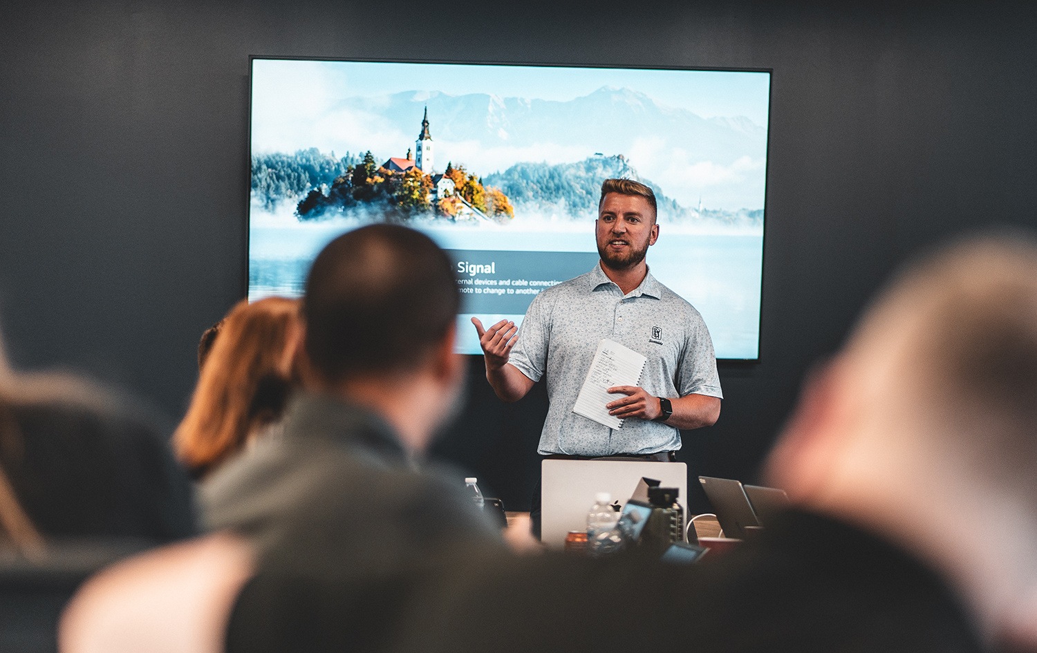 A GlideFast presenter speaking to colleagues gathered around a conference table