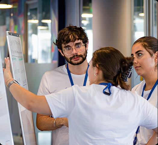 Three participants gather around a whiteboard in a photograph published by Global App Testing
