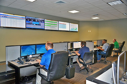 Engineers at desks and monitoring screens in the GDS Network Operations Center