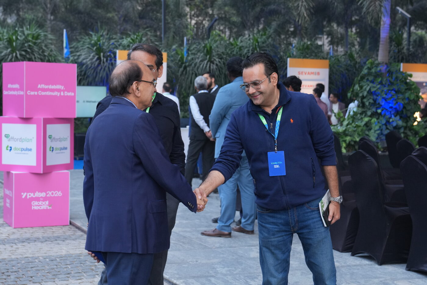 Attendees greeting one another beside healthcare company displays at Pulse 2026