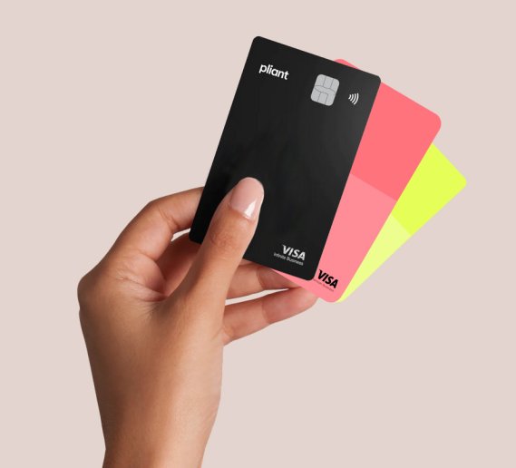 A hand holding three Pliant corporate payment cards