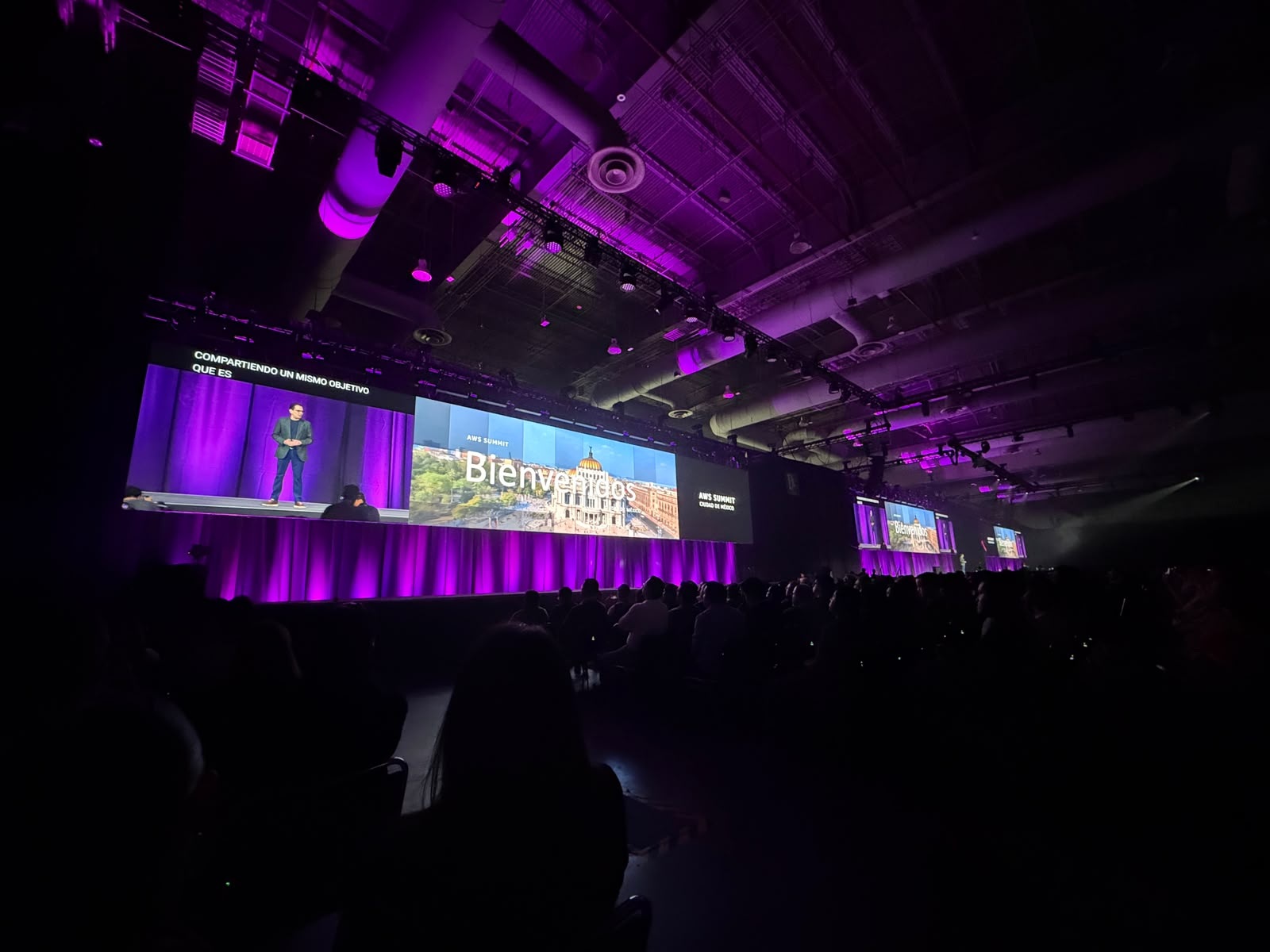 Audience and purple-lit stage at AWS Summit Mexico, in an event photograph published by GlobalTask