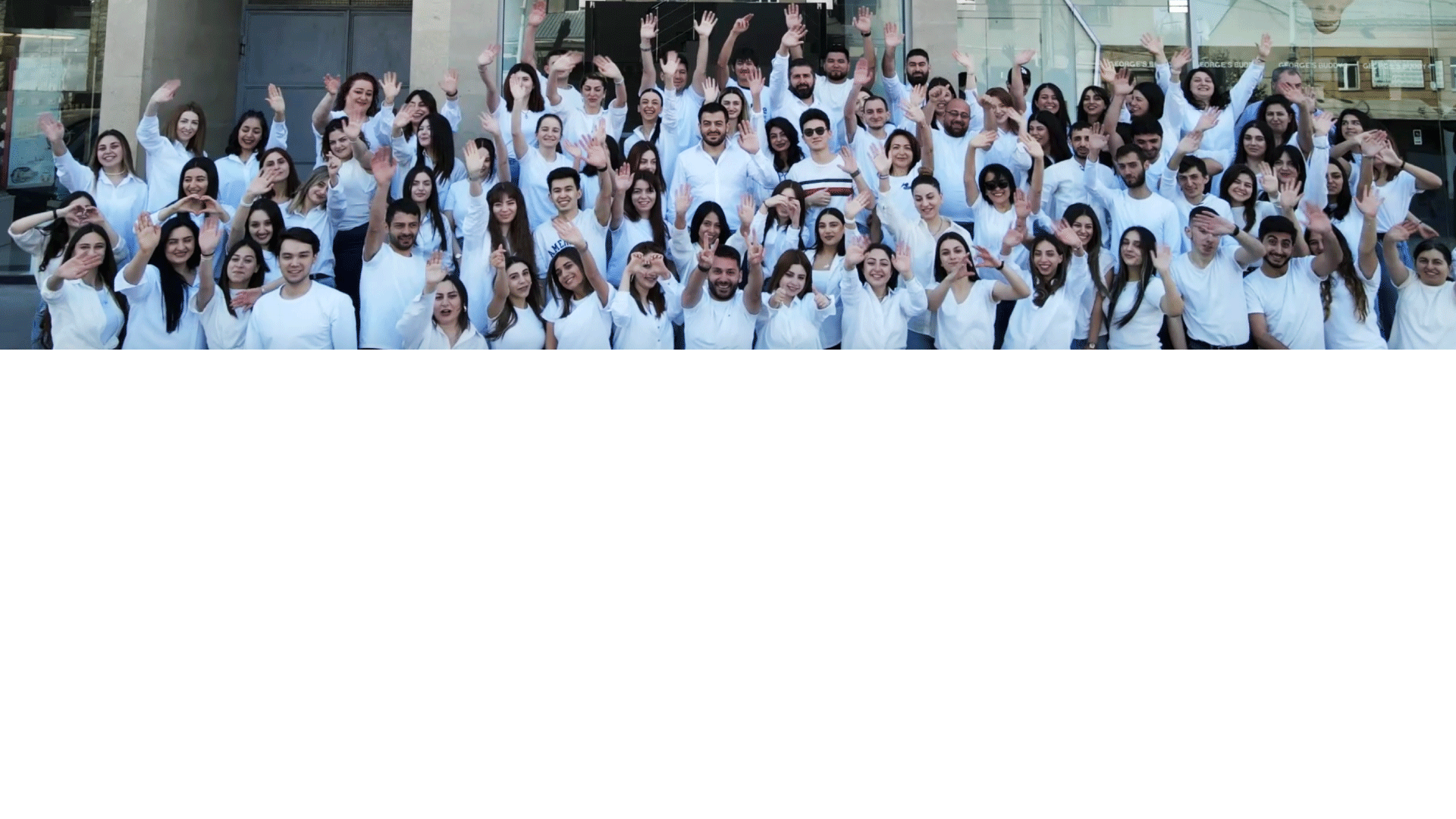 A large group of Globbing team members waving outside an office