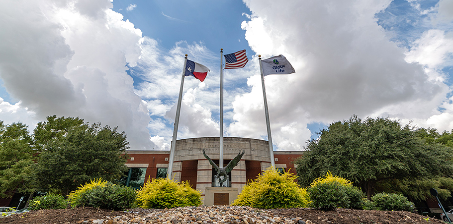 Flags and an eagle sculpture outside a Globe Life home-office building