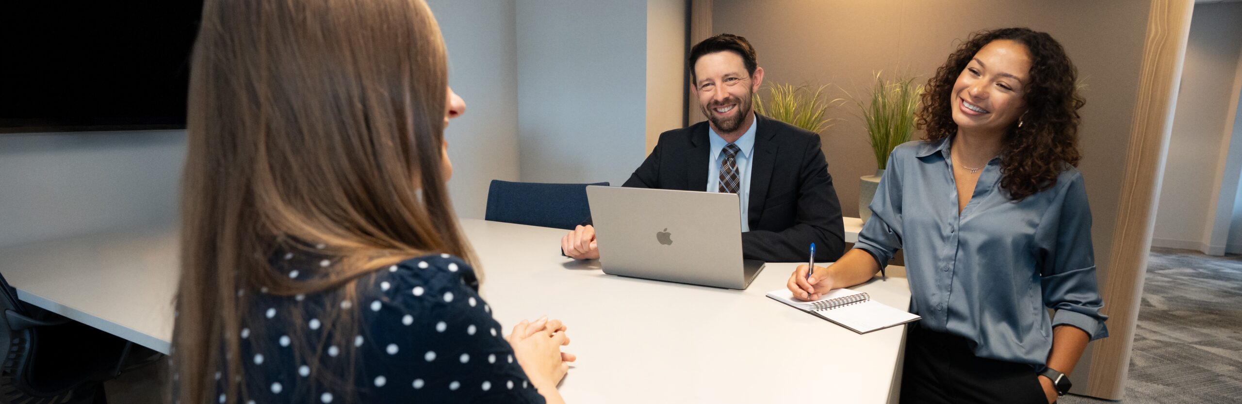 Three people holding a friendly meeting around a conference-room table