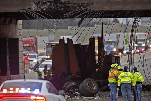 Emergency crews inspect a truck lodged beneath the damaged Rockville Road bridge in Indianapolis
